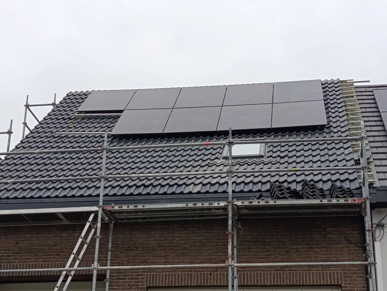 Vernieuwd pannendak met zonnepanelen en stelling
