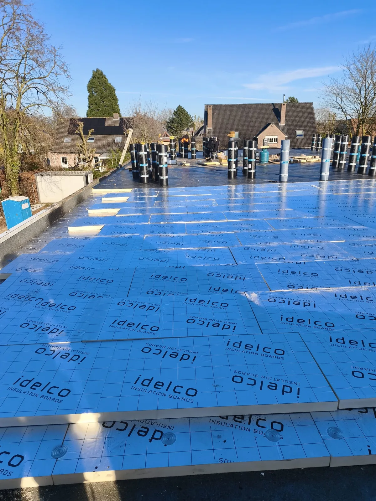Isolatie en roofingrollen op een groot plat dak