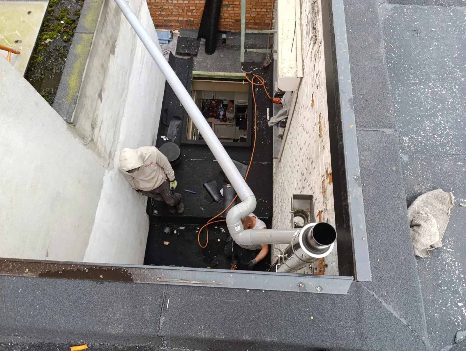 Afwerking van roofing rond een lichtschacht op een plat dak