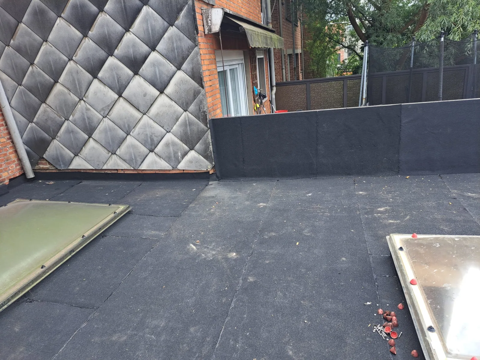 Nieuwe roofing met lichtkoepels langs de gevel