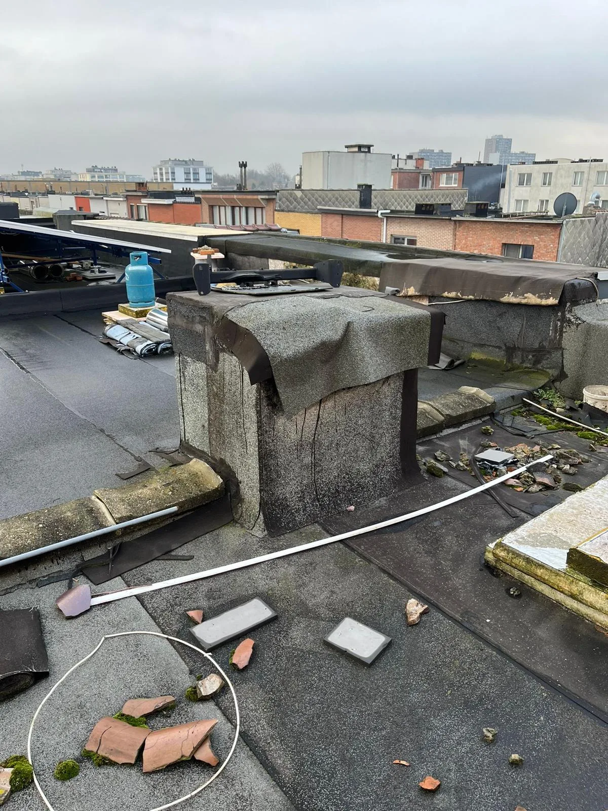 Beschadigd dak met losgekomen stukken en puin