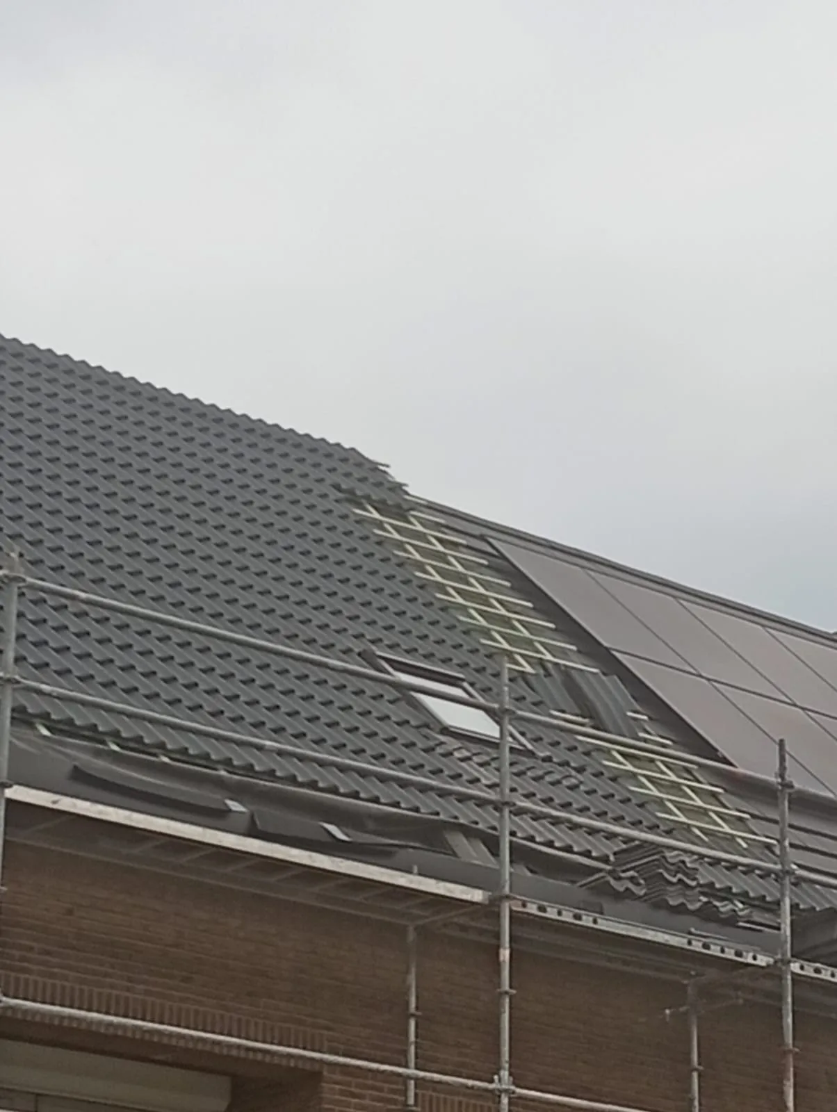 Hellend dak met nieuwe donkere pannen
