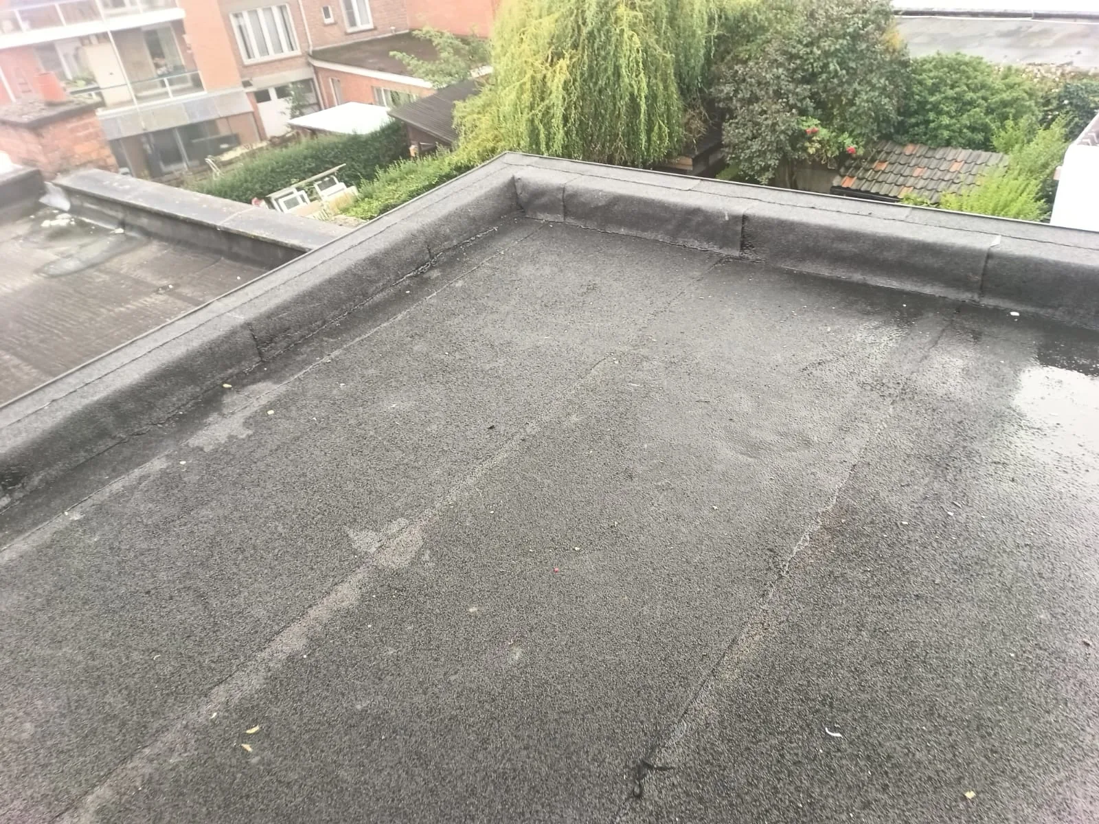 Oud plat dak met slijtage aan de dakbedekking
