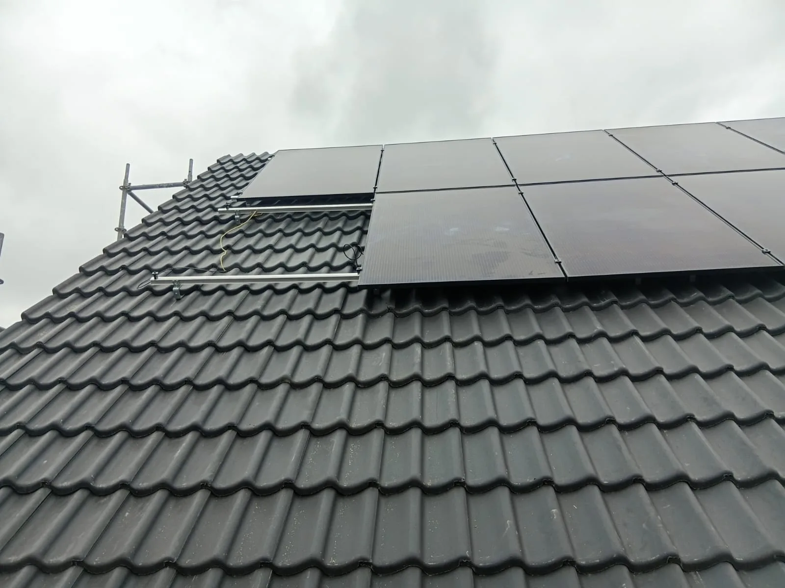 Nieuwe donkere dakpannen met zonnepanelen