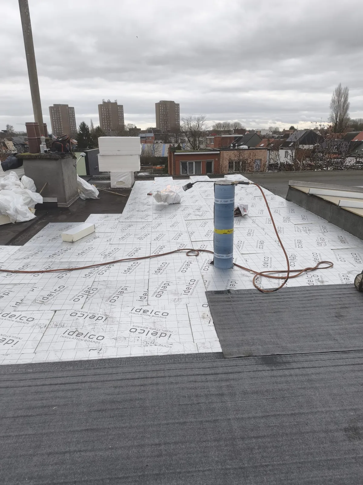Isolatieplaten rond een doorvoer op een plat dak